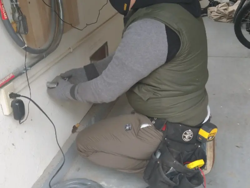 Electrician performing outlet wiring in a Sand Lake garage